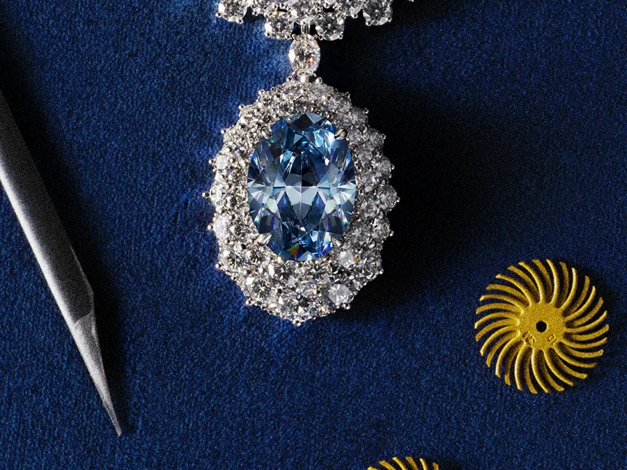 Messika Collier Okavango Blue mit dem blauen Diamanten von 20,46 Karat aus Botswana neben Juwelierwerkzeug